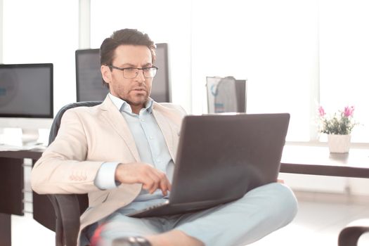 businessman using a laptop sitting at his Desk.people and technology