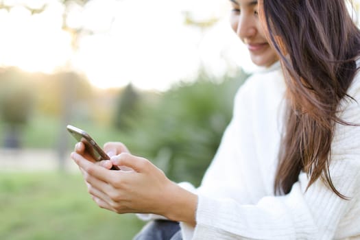 Focus on smartphone in chinese woman hands. Concept of asian modern technology.