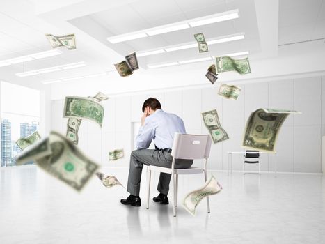 young businessman sitting on a chair with his head in his hands