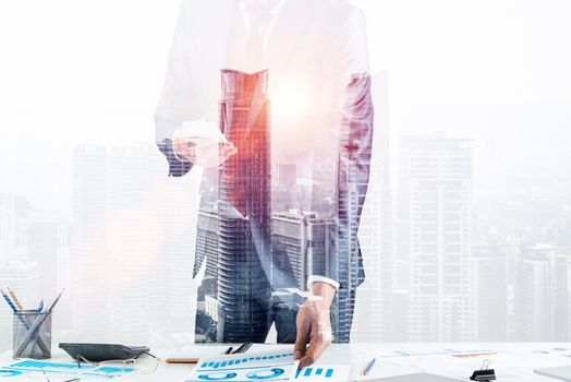 Businessman standing near office desk and using smartphone. Online stock trading and investment. Corporate manager in suit and tie working with business analytics. Entrepreneurship and leadership.