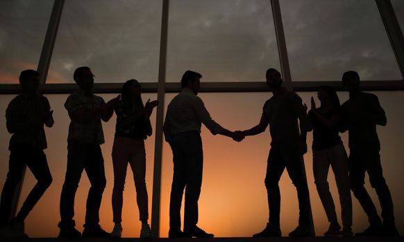 in full growth.handshake of business partners on the background of the office window