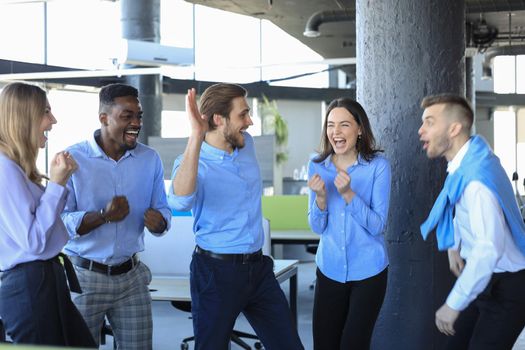 Happy business people laugh in the office. Successful team coworkers joke and have fun together at work