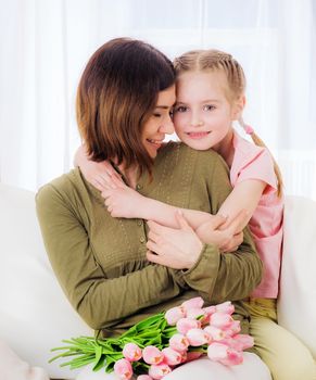 Little loving girl embracing her beatiful mother