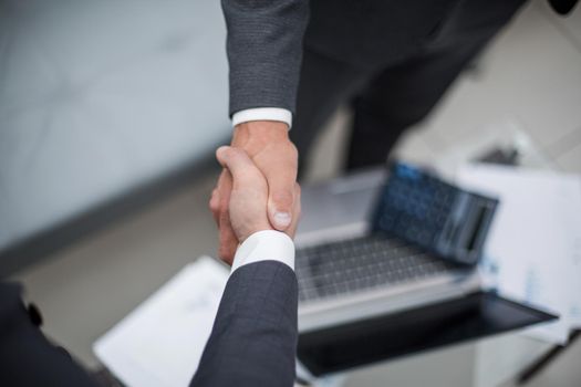 close up.handshake trading partners over the desktop.business background