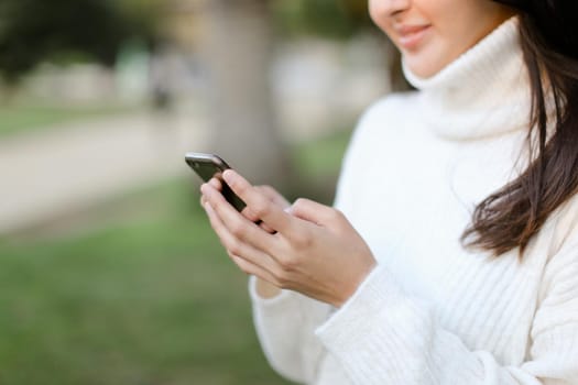 Focus on smartphone in chinese girl hands. Concept of modern technology.