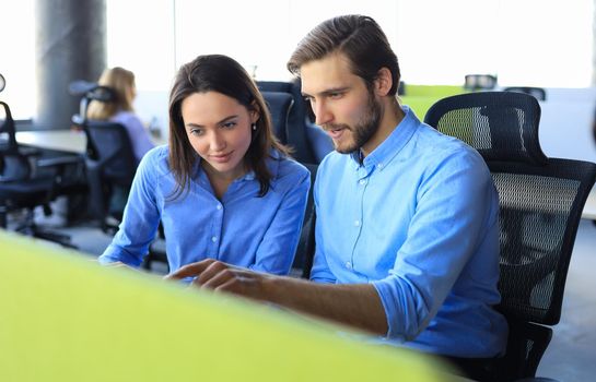 Two collegues discussing documents and other working moments in office