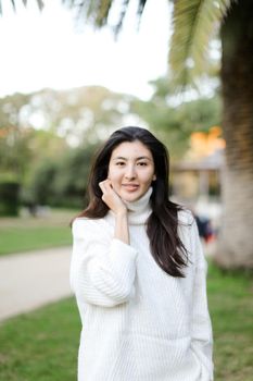 Portrait of asian girl walking outdoors. Concept of beauty and nature.