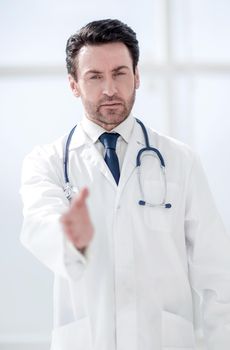 background image of the doctor holding out his hand for greeting . photo with copy space