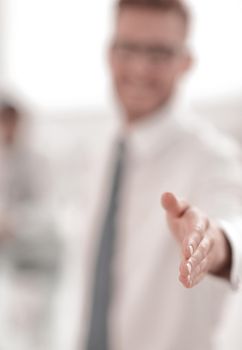blurred image. business man holding out his hand for a handshake.business background