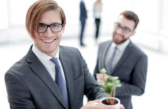 start-up.young businessman shows young sprout. photo with copy space.