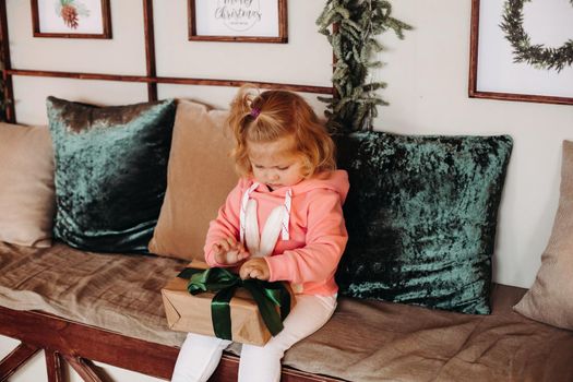 Picture of cute little girl opens a gift