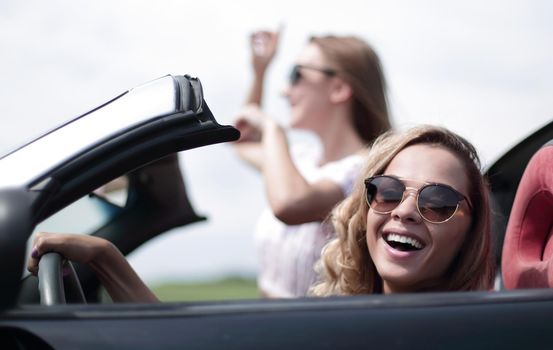 close up.two girlfriends traveling in a convertible car . fashionable lifestyle