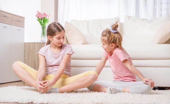 Two yoga-practicing girls are meditating with joy at home