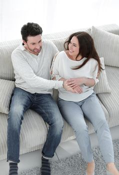 laughing couple having fun on the couch in the living room.the concept of happiness