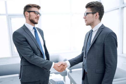 close up.handshake business people in a modern office.concept of partnership