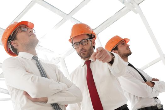 close up.a confident businessman in a safety helmet pointing at you.the concept of cooperation