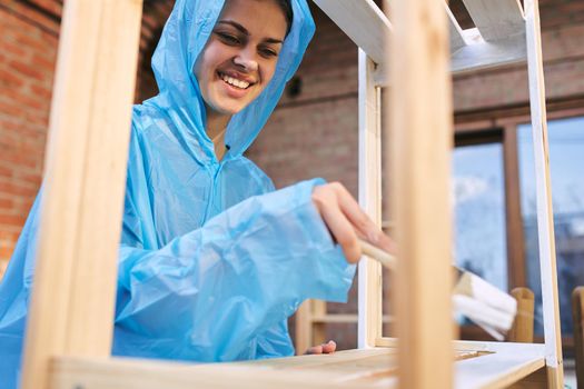 cheerful woman house painter repairing wooden structure. High quality photo