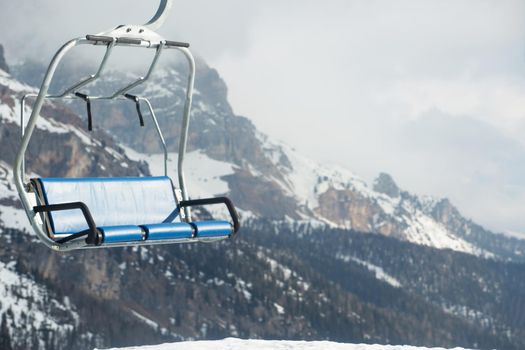 Ski lift chairs at ski resort in winter mountains