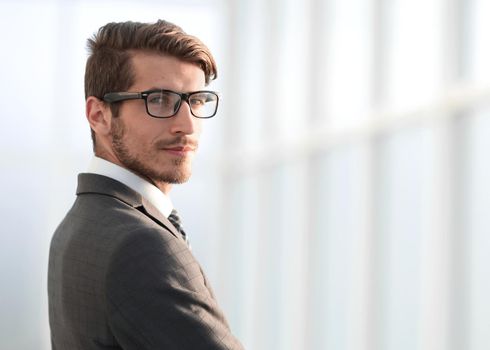 young businessman standing near the office window. photo with copy space