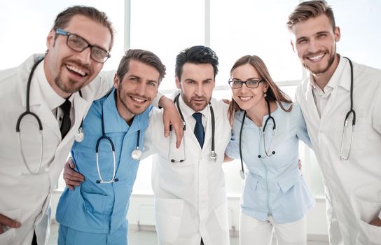 Excited happy smiling group of people in hospital, wear white lab coats