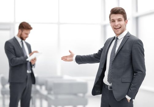Young businessman invites to his office.photo with copy space