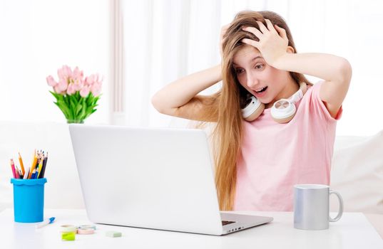 Beatiful girl is amazed about pictures on her personal laptop