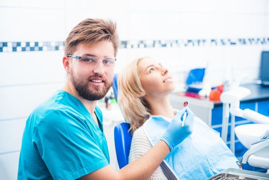 Dentist with equipent examinating young girl