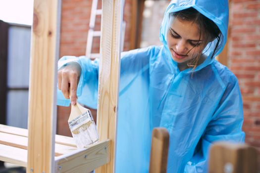 woman in protective suit painting wood renovation design. High quality photo