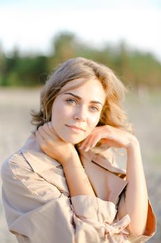 Closeup caucasian woman standing on beach and wearing coat. Concept of enjoying summer and autumn photo session,resting outside.