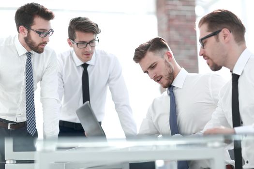 business colleagues standing near the desktop.the concept of teamwork