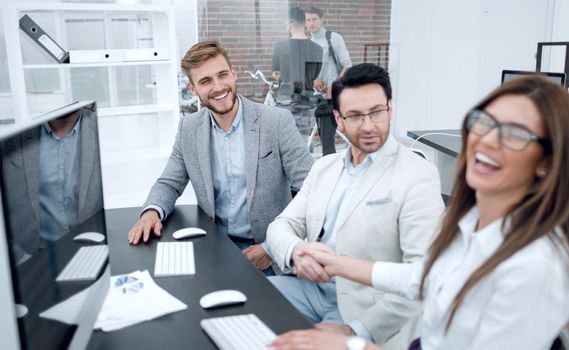 smiling colleagues sitting at the Desk.business concept