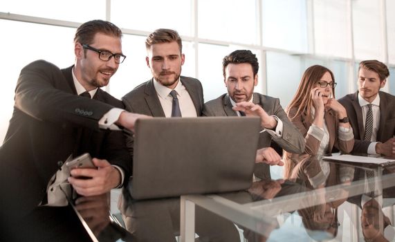 Businessmen and businessmen using laptop together, sitting in front of windows of office building