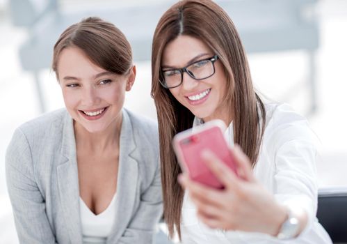 two business women taking selfies in the office. photo with copy space