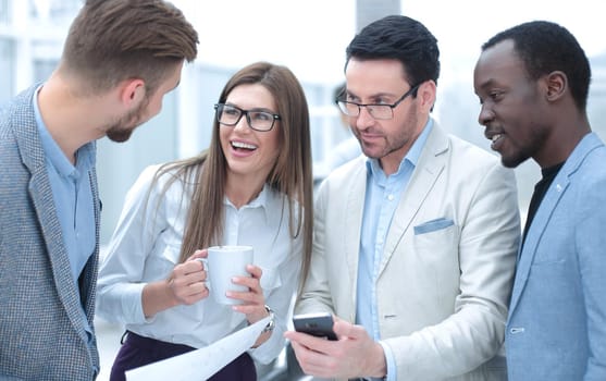 close up. business team reads SMS on smartphone. office weekdays