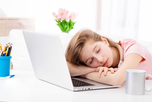 Cute teen fell asleep at desk when working on laptop