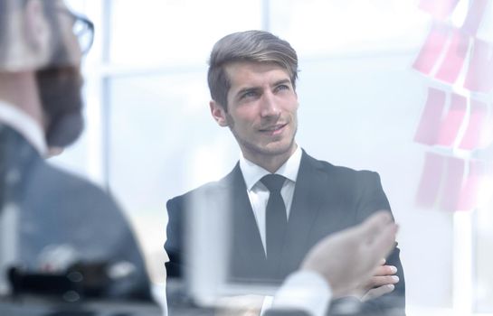 business colleagues discussing business stickers-notes on glass .the concept of a startup