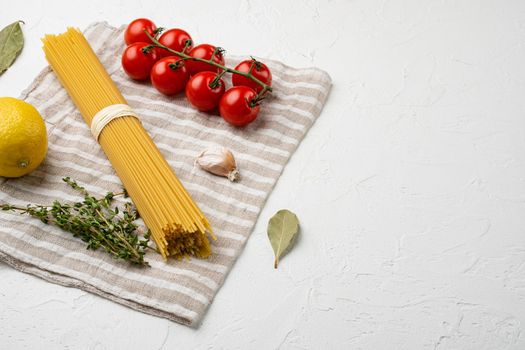 Spaghetti raw dry ingredients set, on white stone table background, with copy space for text