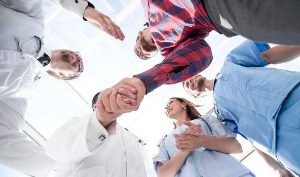 view from the bottom of a large medical team standing in a circle, smiling