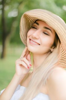 Portrait of young nice caucasian girl wearing hat and smiling. Concept of beauty, female person and summer fashion.