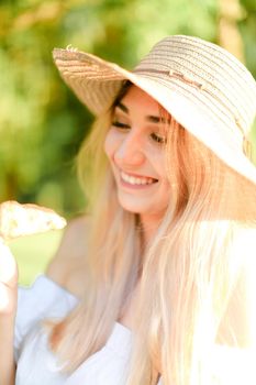 Portrait of young smiling caucasian girl in hat keeping croissant. Concept of beauty, female person and summer fashion, bakery products.