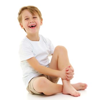 A handsome little boy laughs cheerfully in the studio on a white background. He is dressed in a pure white T-shirt on which you can put any picture or inscription. The concept of children's emotions, advertising. Isolated on white background.
