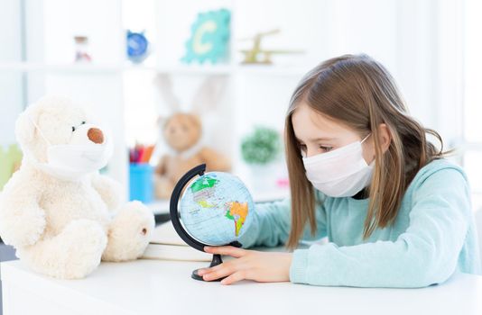 Beautiful school girl with teddy bear studying at home