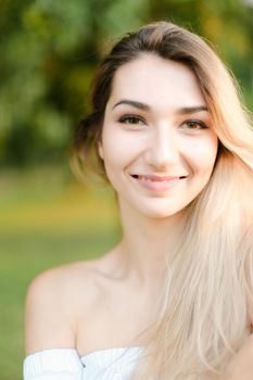Portrait of young nice smiling girl, green background. Concept of beauty and everyday makeup.