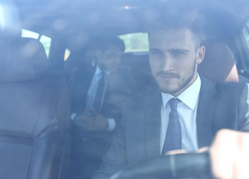 serious businessman behind the wheel of a car.business concept