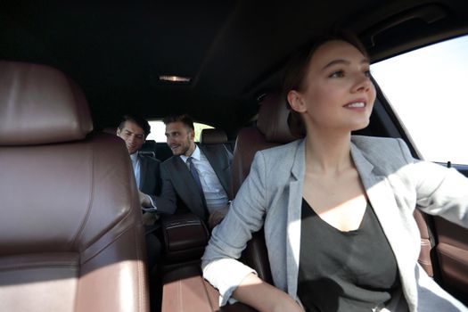 business team sitting in a modern car. business-trip