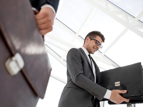 closeup of a lawyer opening briefcase with documents