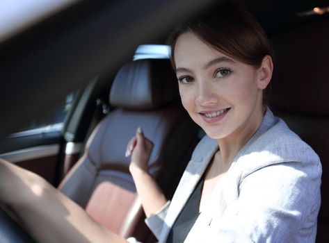 successful business woman sitting behind the wheel of a car. business-trip