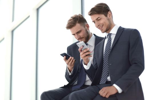 business colleagues read media files on their smartphones.people and technology