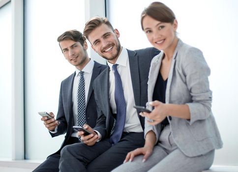 smiling employees using their smartphones.people and technology