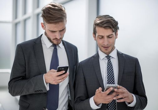 close up.young employees using their smartphones.people and technology